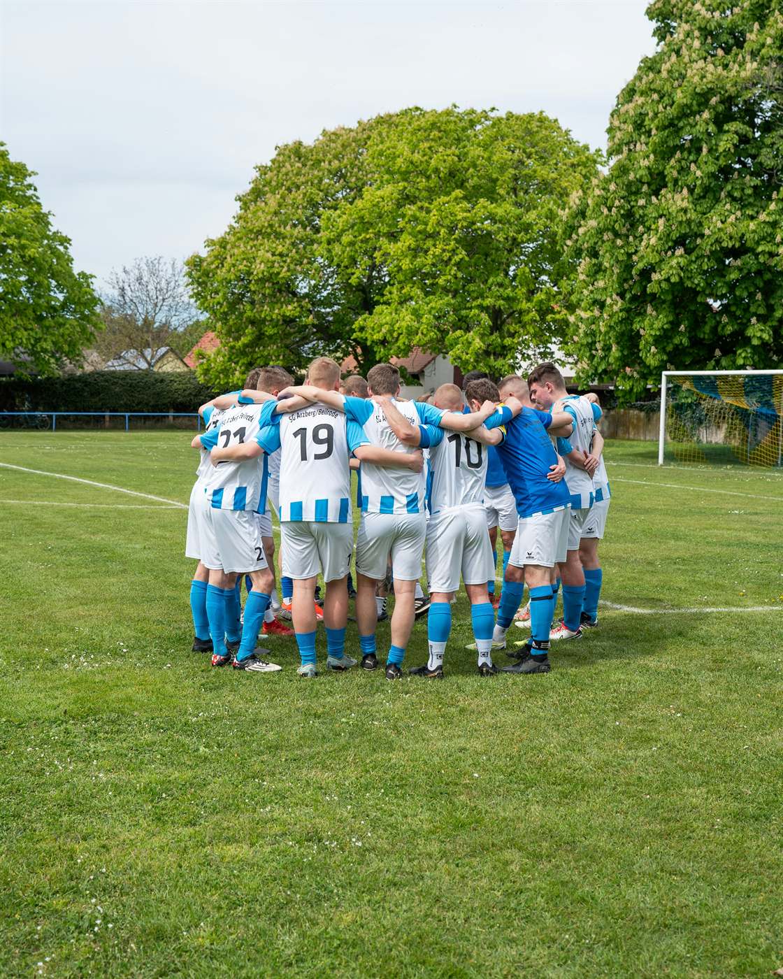 Soccer team huddled together in matching kit before a match