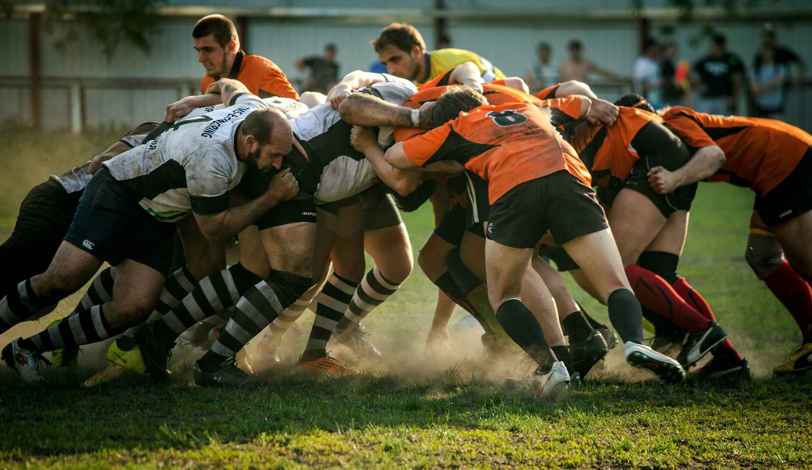 Rugby players in a scrum wearing team kit
