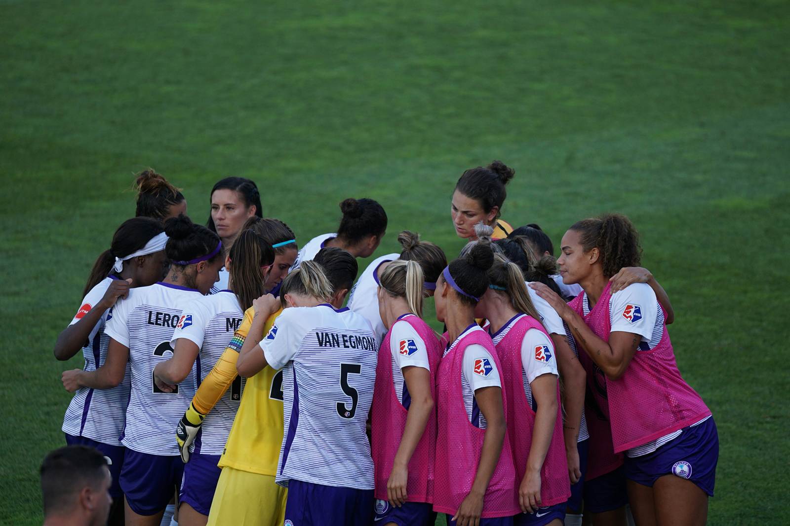 Women's soccer team gathered on the field during a match